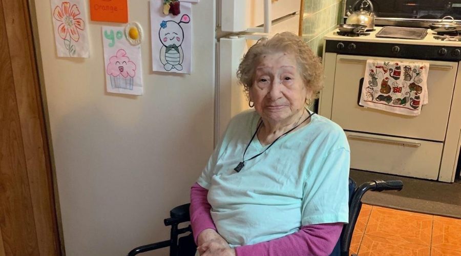 Meals on Wheels Client, Eulalia, next to some of the cards she's received from volunteers.