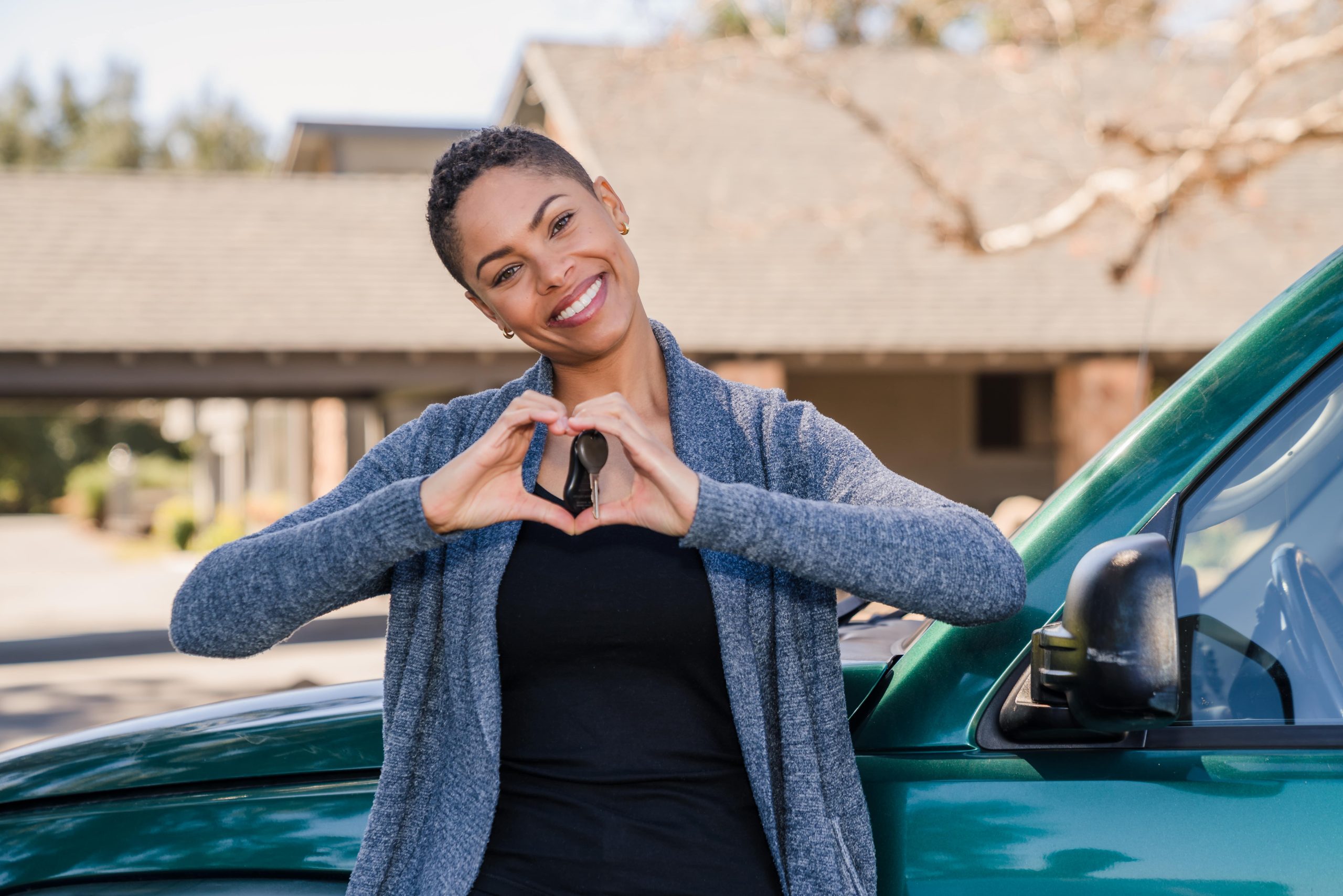 Woman with car keys and house in background
