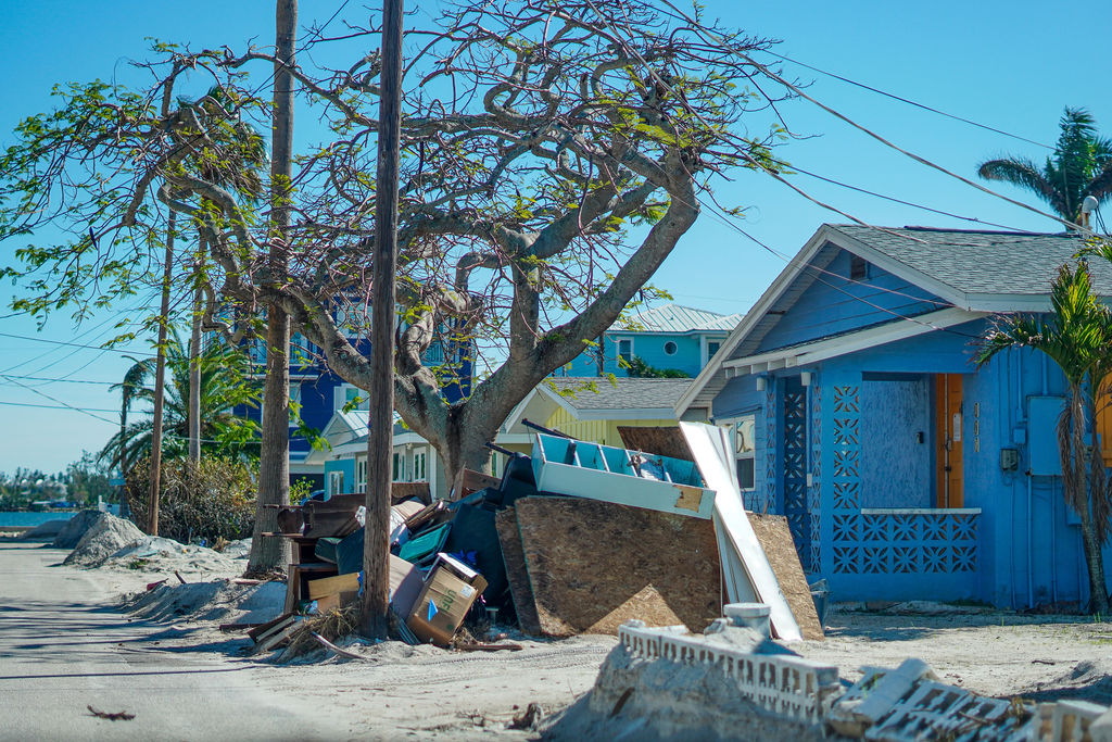 Pile of wood and materials next to house after hurricane destruction in Anna Maria