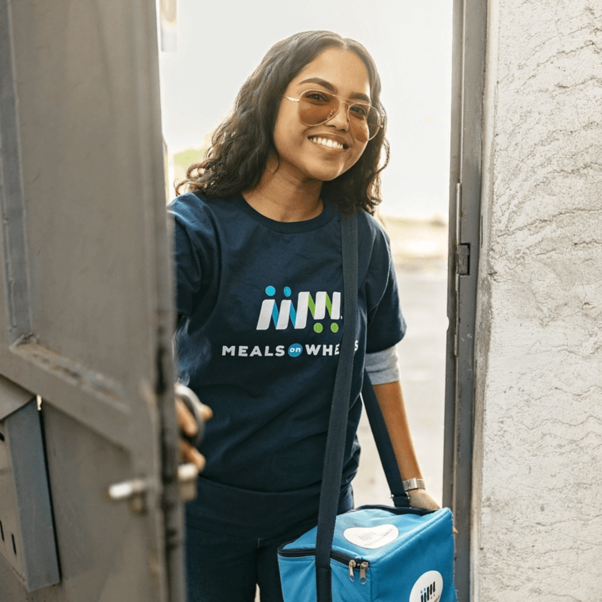 Asian Female Volunteer MOW Blue Shirt Meal Delivery Smiling Branded
