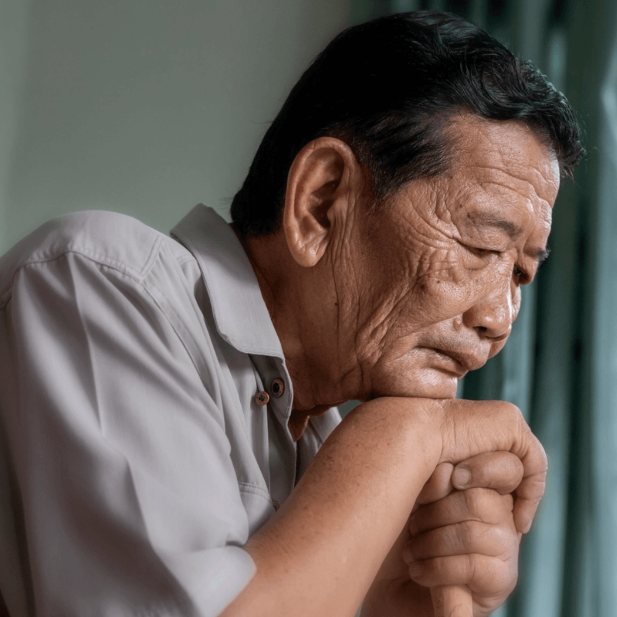 Asian Male Client Gray Shirt Sadly Looking Down on Cane