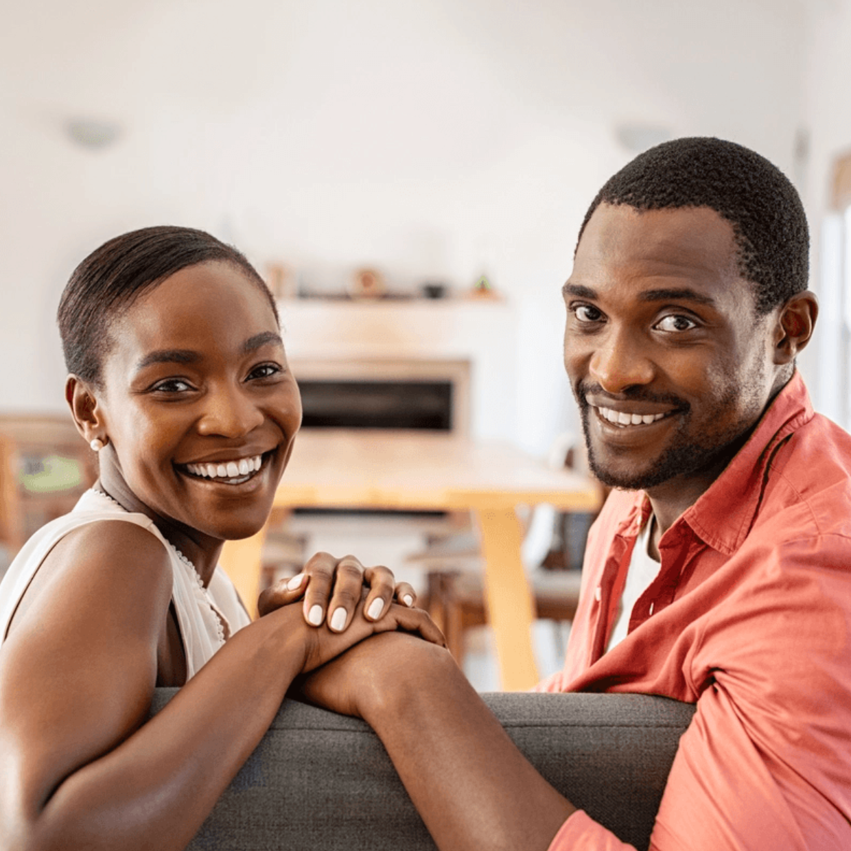 Black Couple Smiling Eye Contact on Couch
