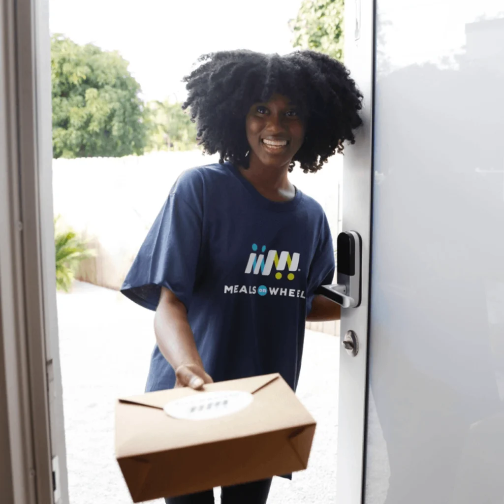 Black Female Volunteer Blue MOW Shirt Meal Delivery at Door