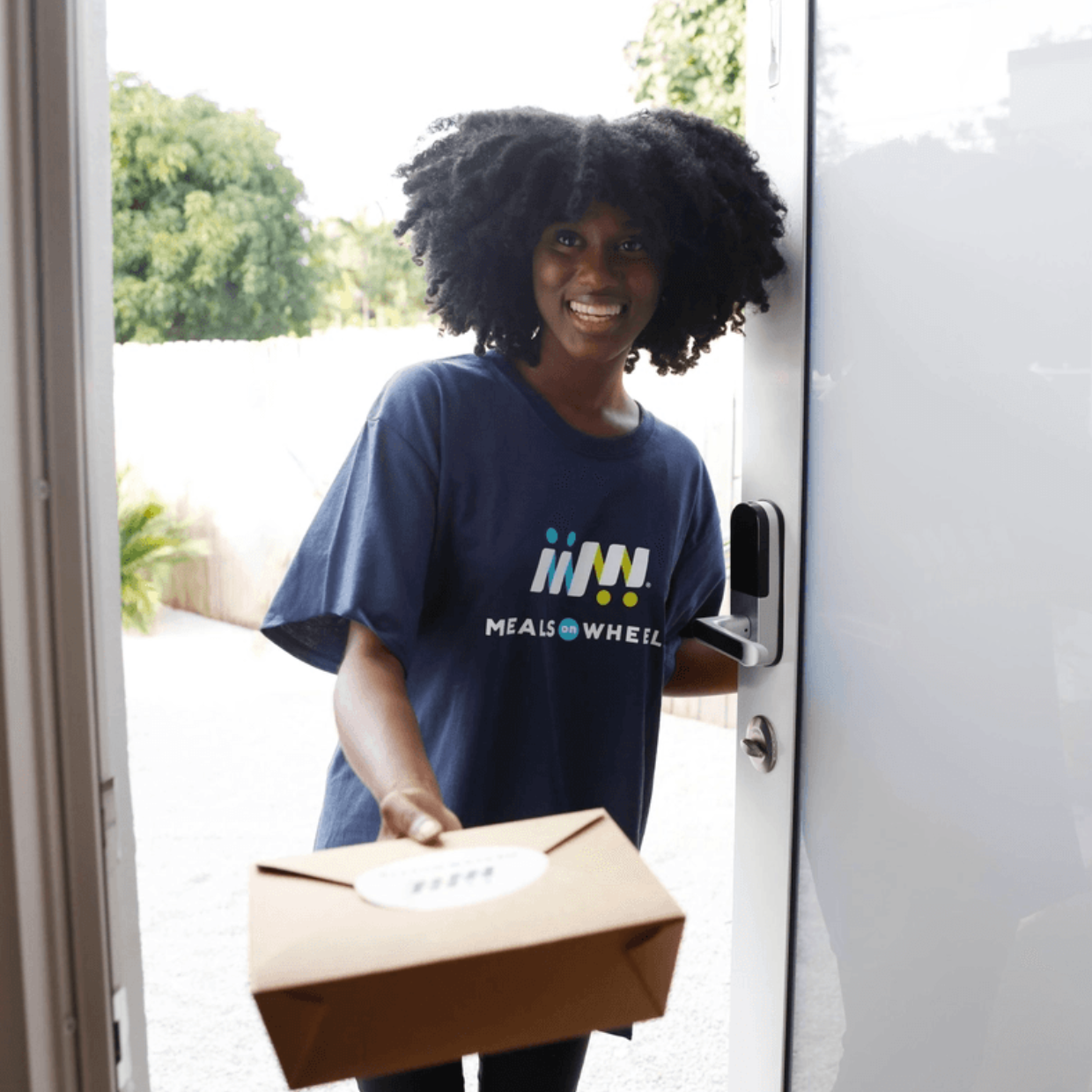 Black Female Volunteer Blue MOW Shirt Meal Delivery at Door