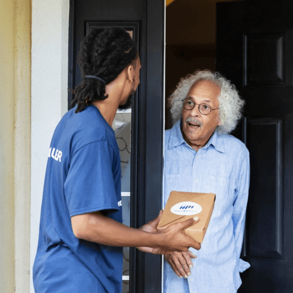 Black Male Volunteer with Black Male Client Meal Delivery at Door Surprised