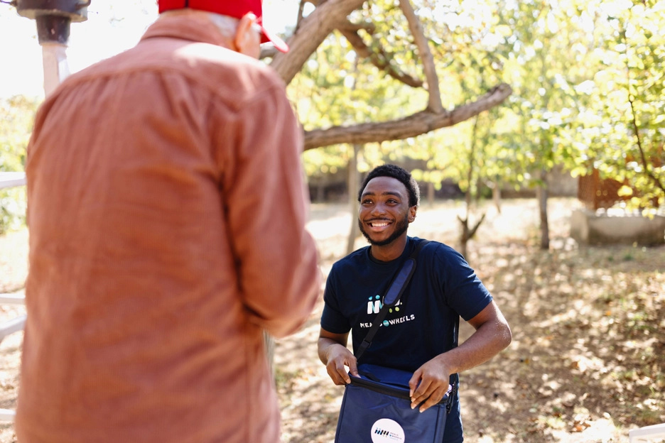 Black Male Volunteer with White Male Client Meal Delivery At Door Happy