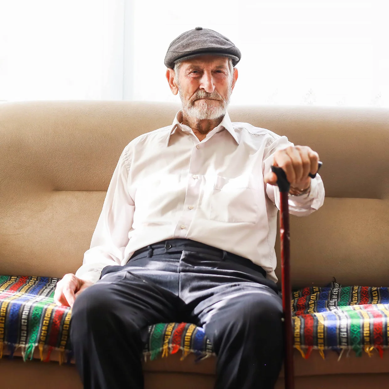 Man sitting on couch with cane
