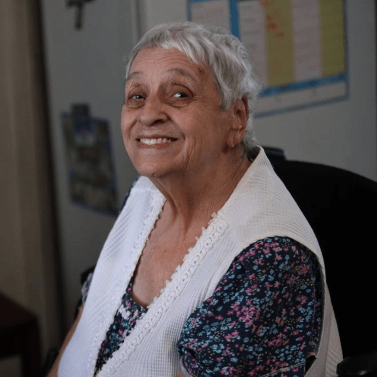 White Female Client White Vest Smiling from Couch