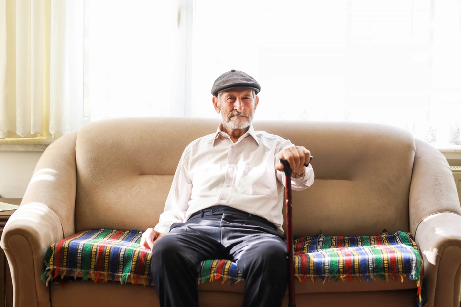 White Male Client White Shirt Sitting on Couch Eye Contact with Cane