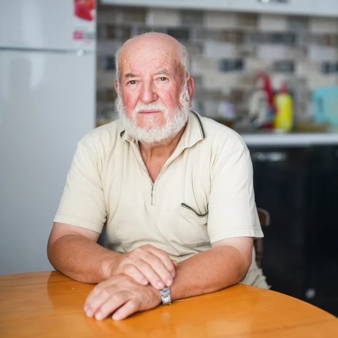 White Male Client Yellow Shirt Sad Staring and Sitting at Table - Meals on Wheels Research