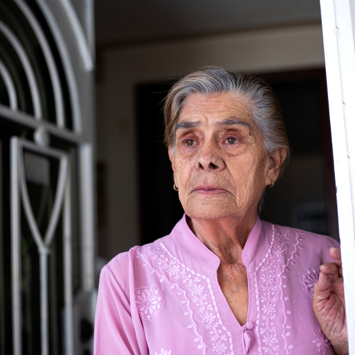 Woman Looking Out Doorway Sadly