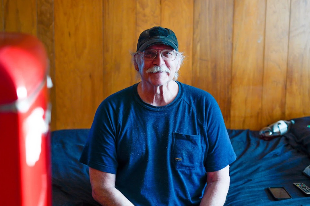 Michael Snodgrass, senior veteran, sitting on bed