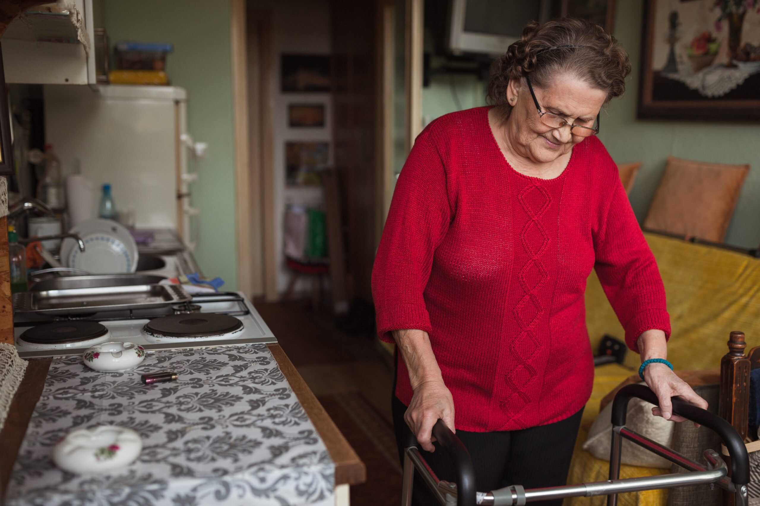 Shot of a old woman walking with the assistance of a walker
