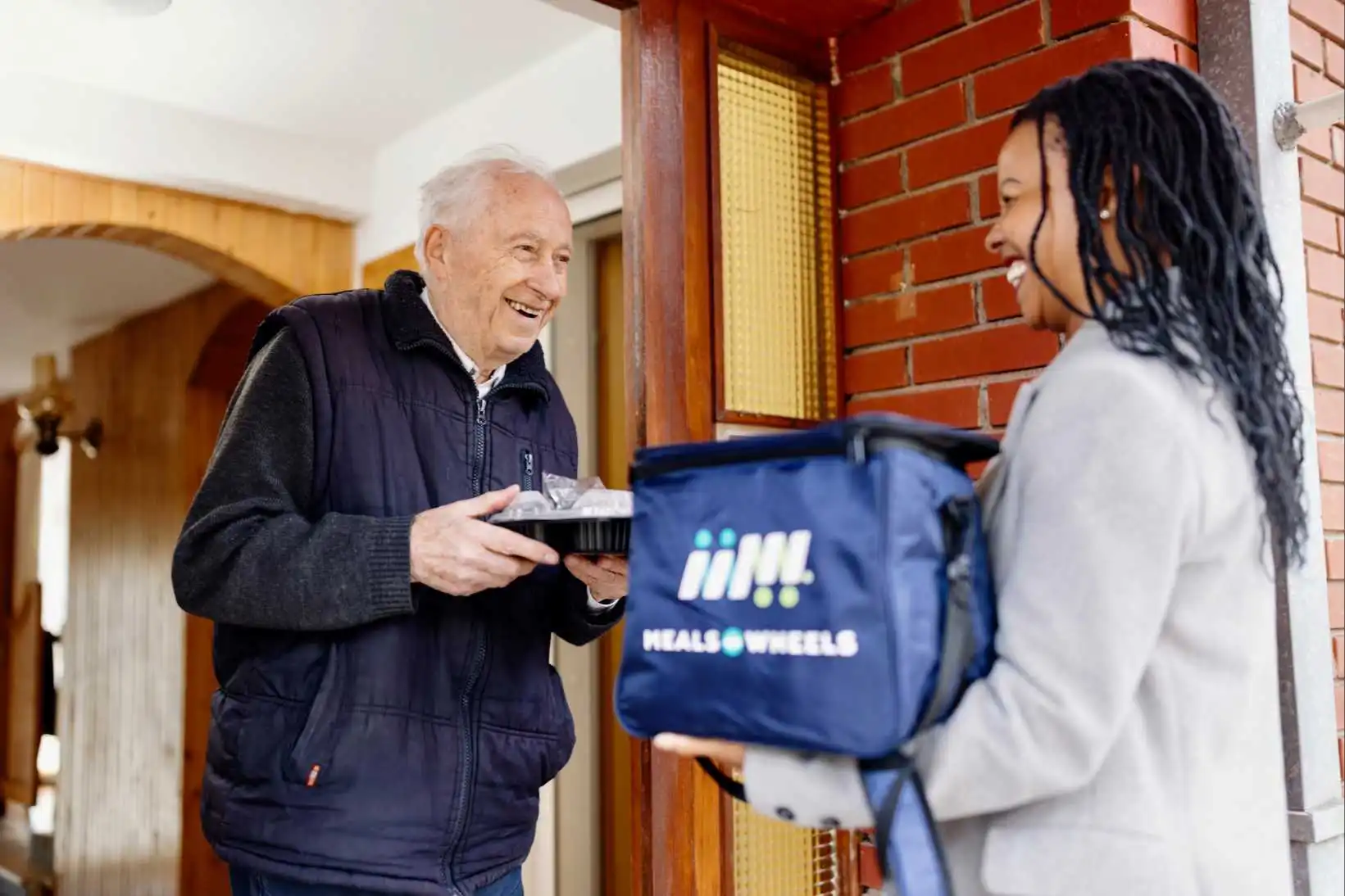 Client and Volunteer delivering with Meals on Wheels Bag