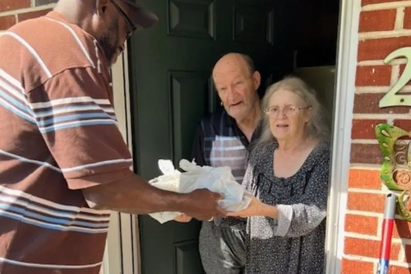 Volunteer delivering food to clients Darlene and Henry