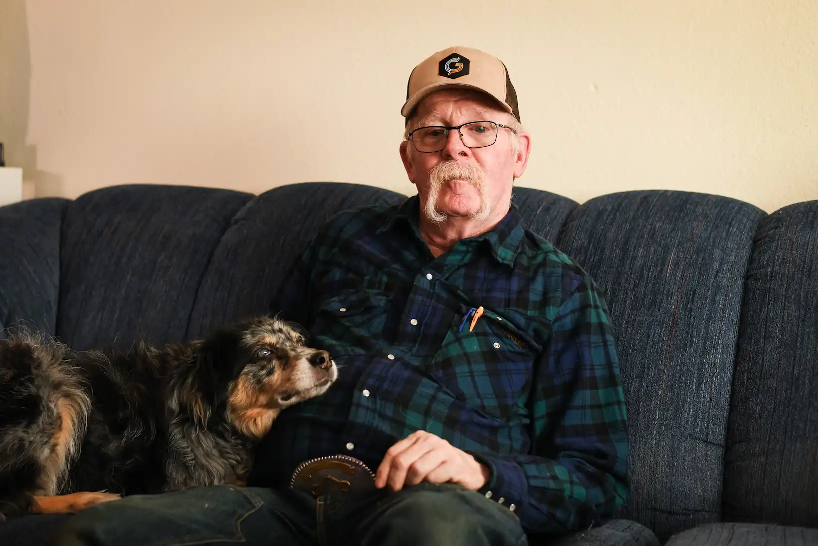 Client, Ron, and his dog Bleau sitting on a couch together