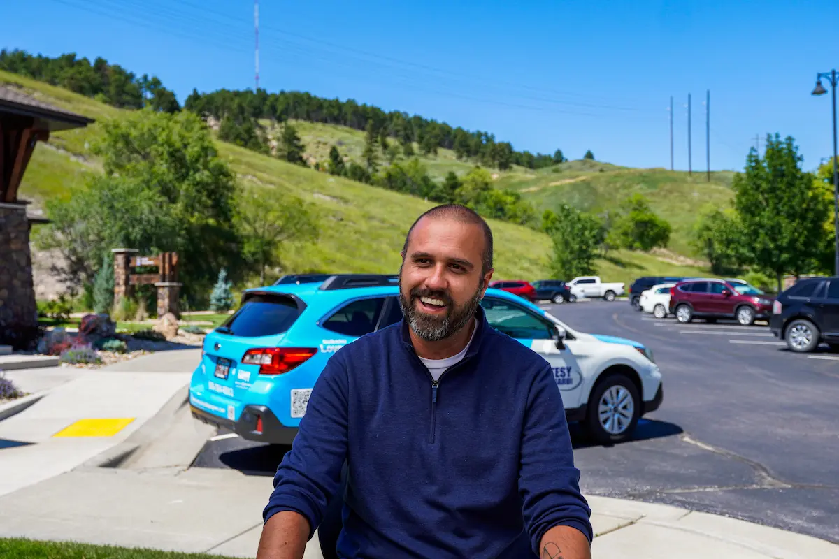 Meals on Wheels volunteer Seth Malott sitting in front of delivery vehicle in South Dakota
