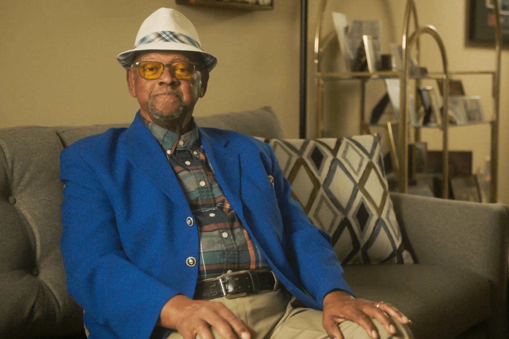 Client, Wilbert, Wearing Blue Blazer Maintaining Eye Contact and Sitting Neutral on Couch