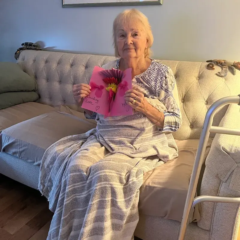Beverley Walder holding a handmade messages of love card.