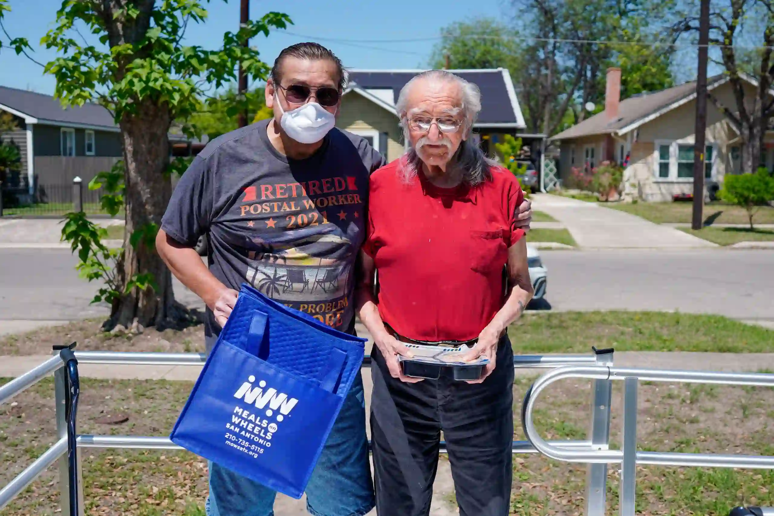 Robert Holguin and Volunteer Holding Meals on Wheels San Antonio Blue Bag