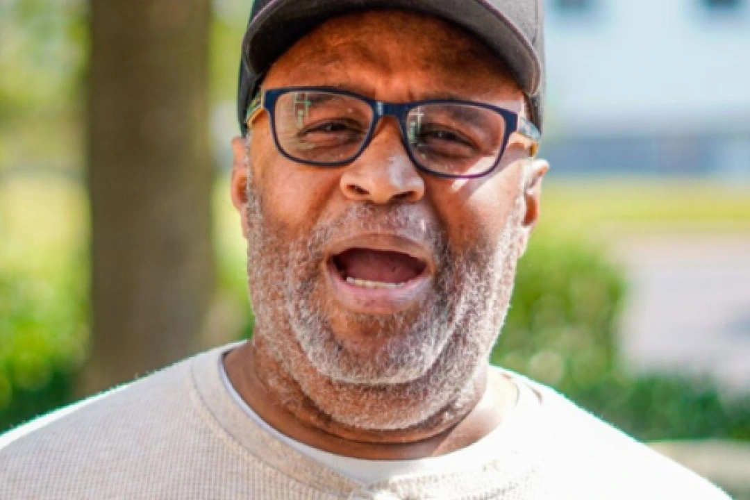 Black male senior, Vernon, talking while wearing glasses- Meals on Wheels volunteer story