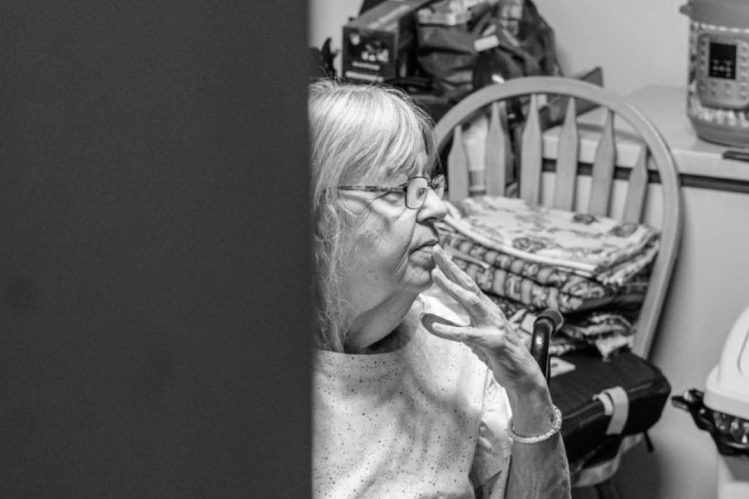 Black and white photo of client, Inez, in the kitchen.