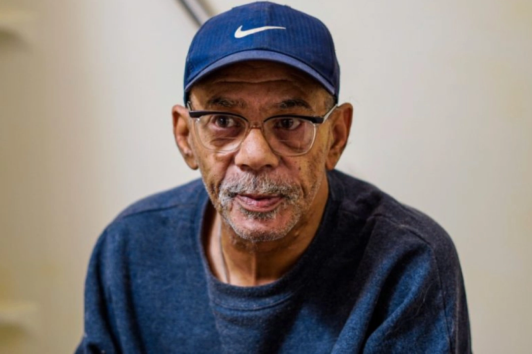 Black male senior Thomas Proudford wearing glasses, navy-blue sweatshirt, and navy-blue Nike hat.