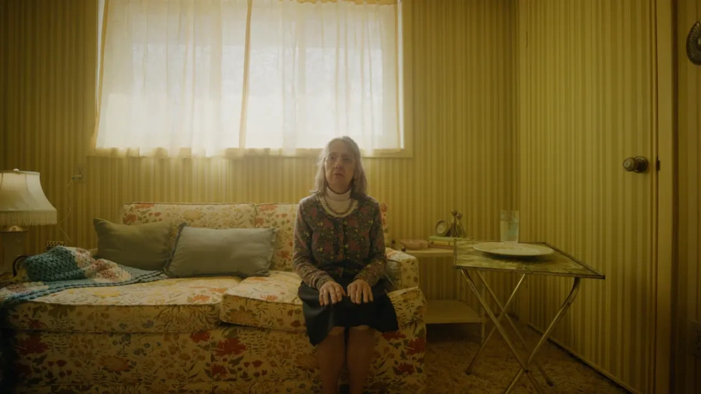 Woman senior sitting on floral couch.