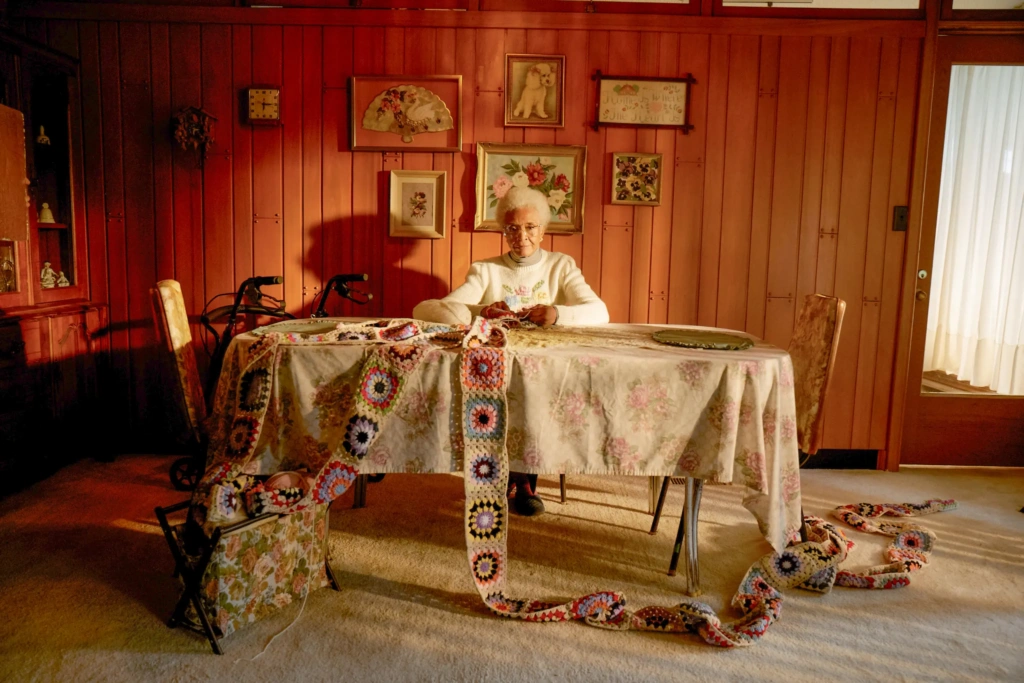 Woman at table waiting with long knitted scarf - Seniors waiting for meals