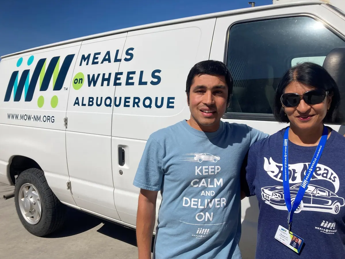 Nutan and her son in front of a Meals on Wheels Albuquerque van