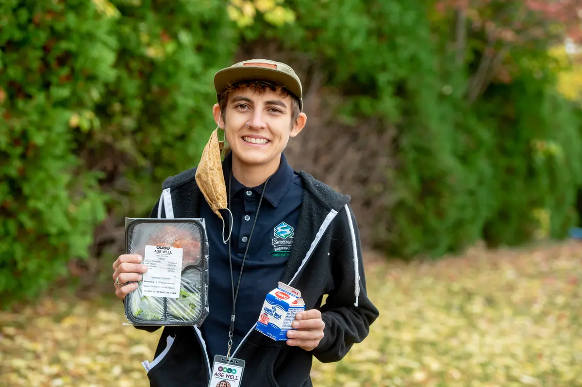 Volunteer Sarah holding a meal and milk