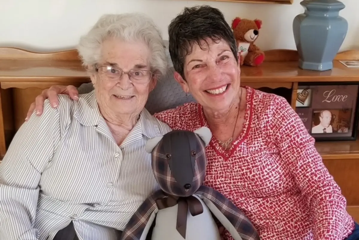 Claire and Harleen smiling together with stuffed animal.